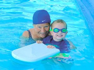 Photo of Nancy Kunau in the Rupert swimming pool with one of her swimming students