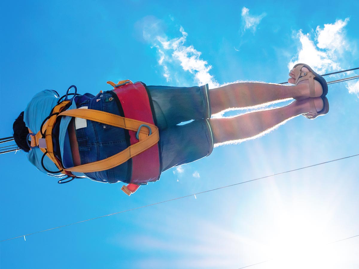 View looking up at someone riding a zipline