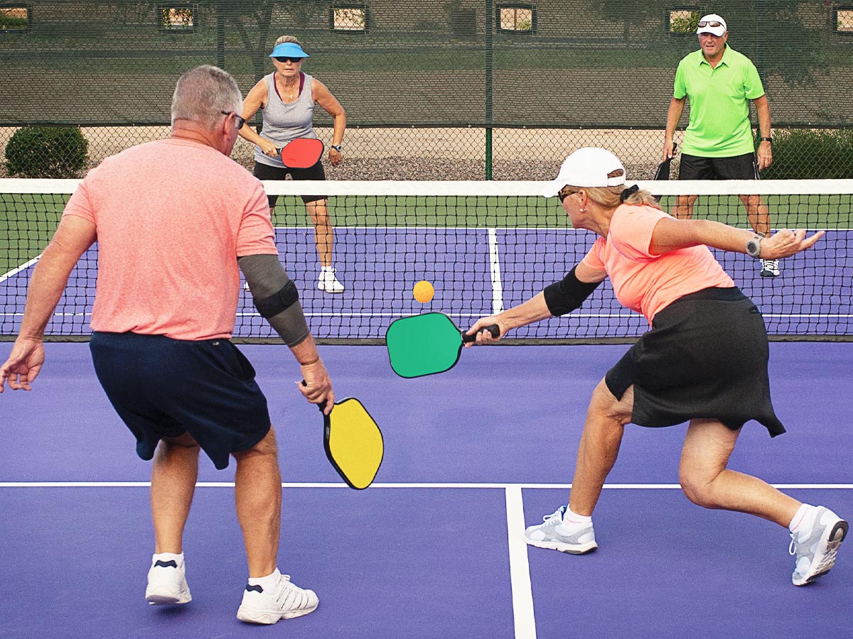 Photo of four seniors playing doubles pickleball
