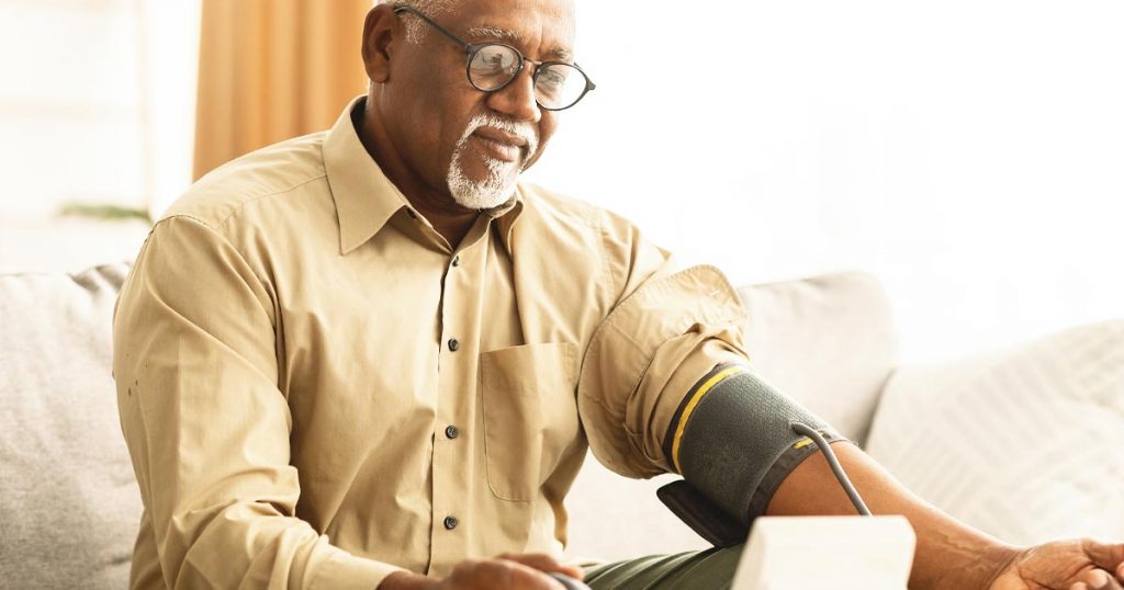 Photo of a senior man taking his own blood pressure