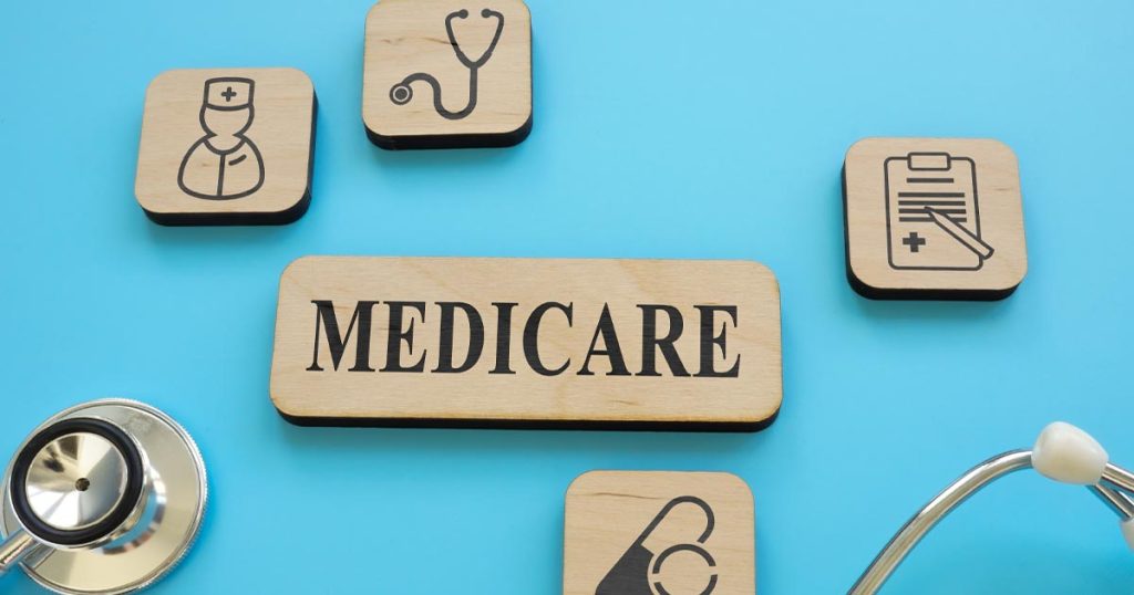Wood tiles with medical icons and text that reads "Medicare." Tiles and a stethoscope sit on a blue background.