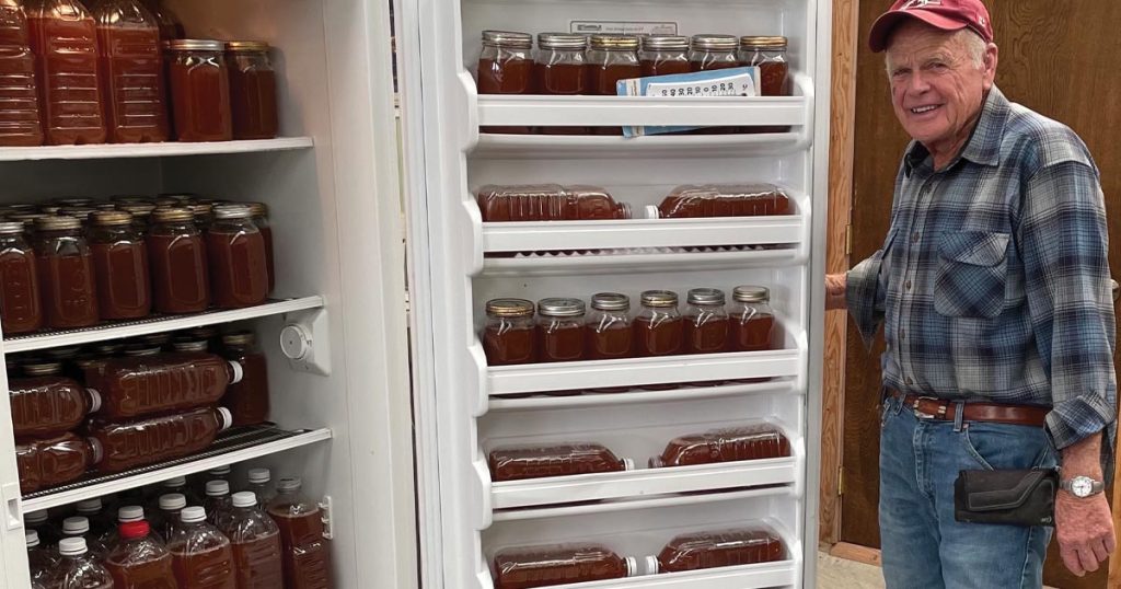 Cleve Smith opening a fridge full of home-pressed apple cider