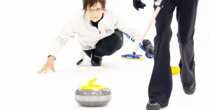 Nanette Dupont throwing the curling stone and the October 2022 Helena Bonspiel