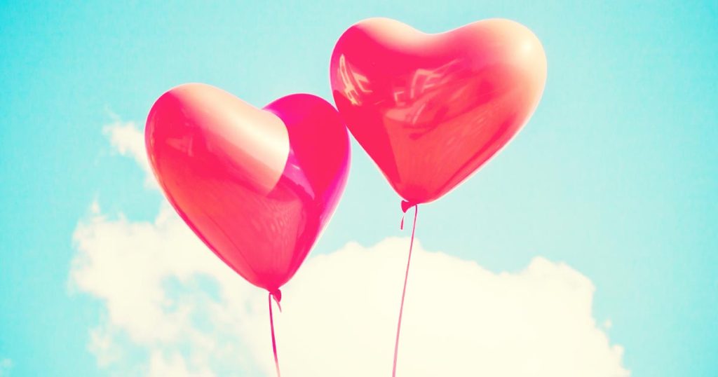 Image of two heart-shaped balloons floating int the sky with clouds, for an article about matchmakers
