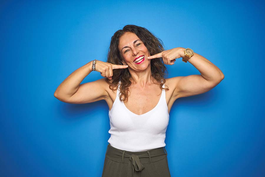 Woman pointing at teeth.